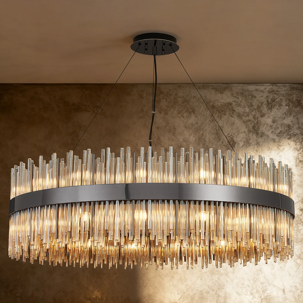Oval chandelier with a dark metal frame and clear glass rods of varying lengths, illuminated from within
