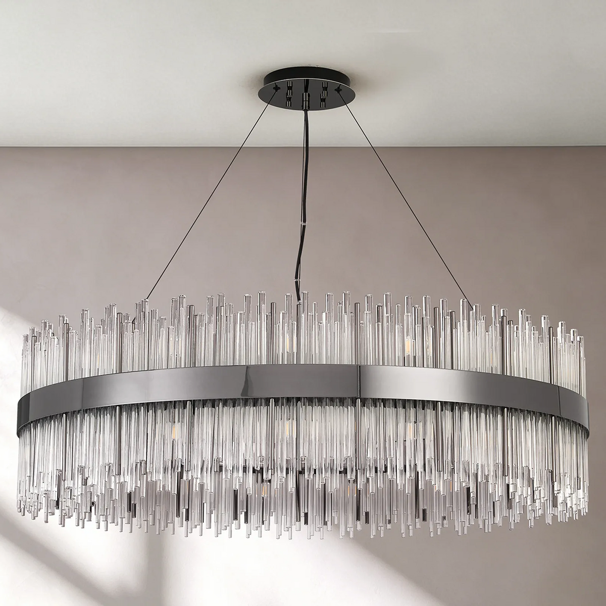 Oval chandelier with a dark metal frame and clear glass rods hanging at varying lengths