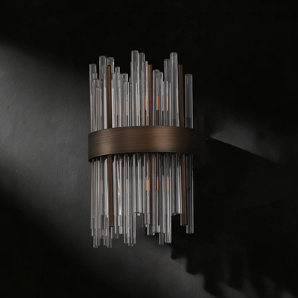 Wall sconce with clear glass rods and a bronze metal band