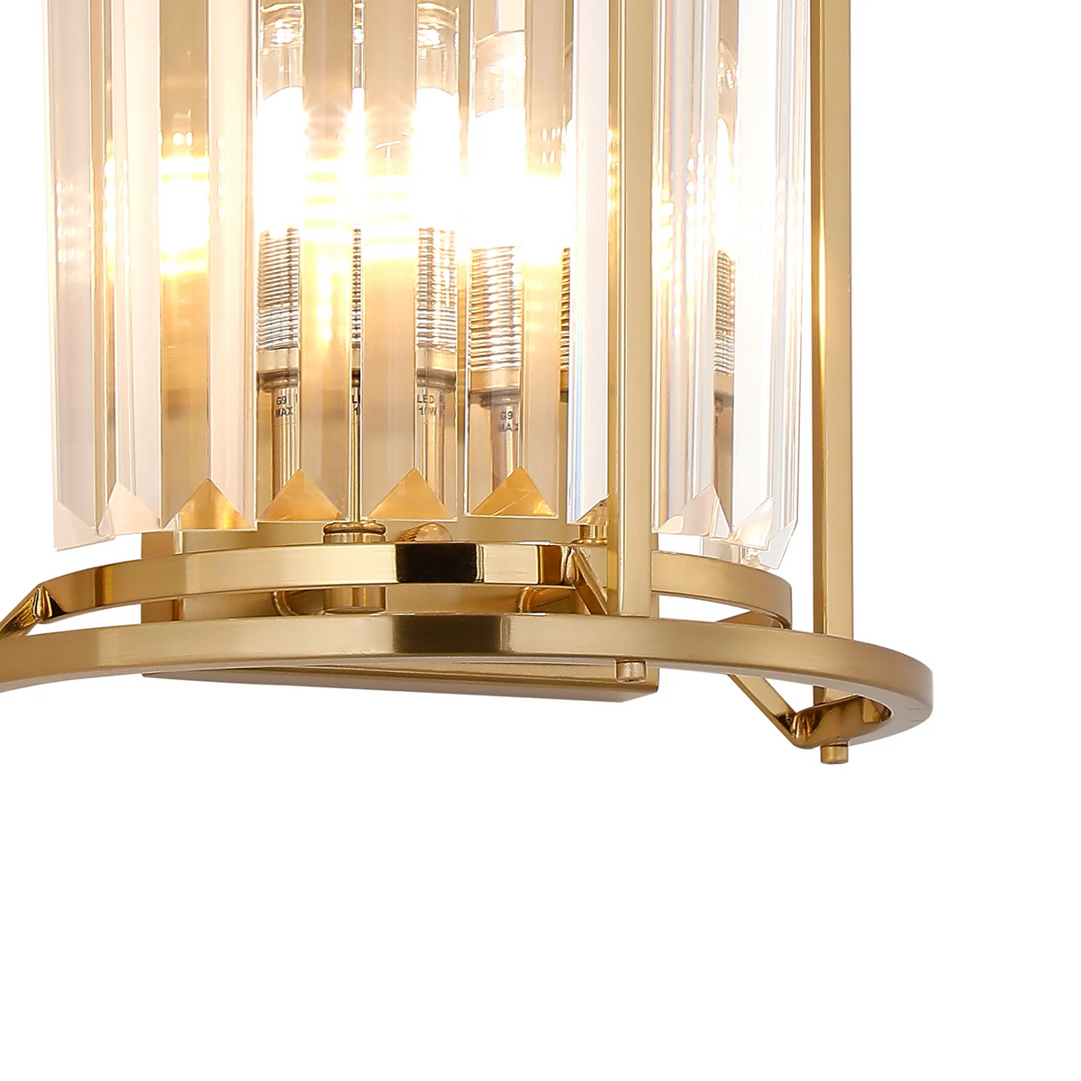 Close up of a gold and crystal wall sconce with light bulbs visible
