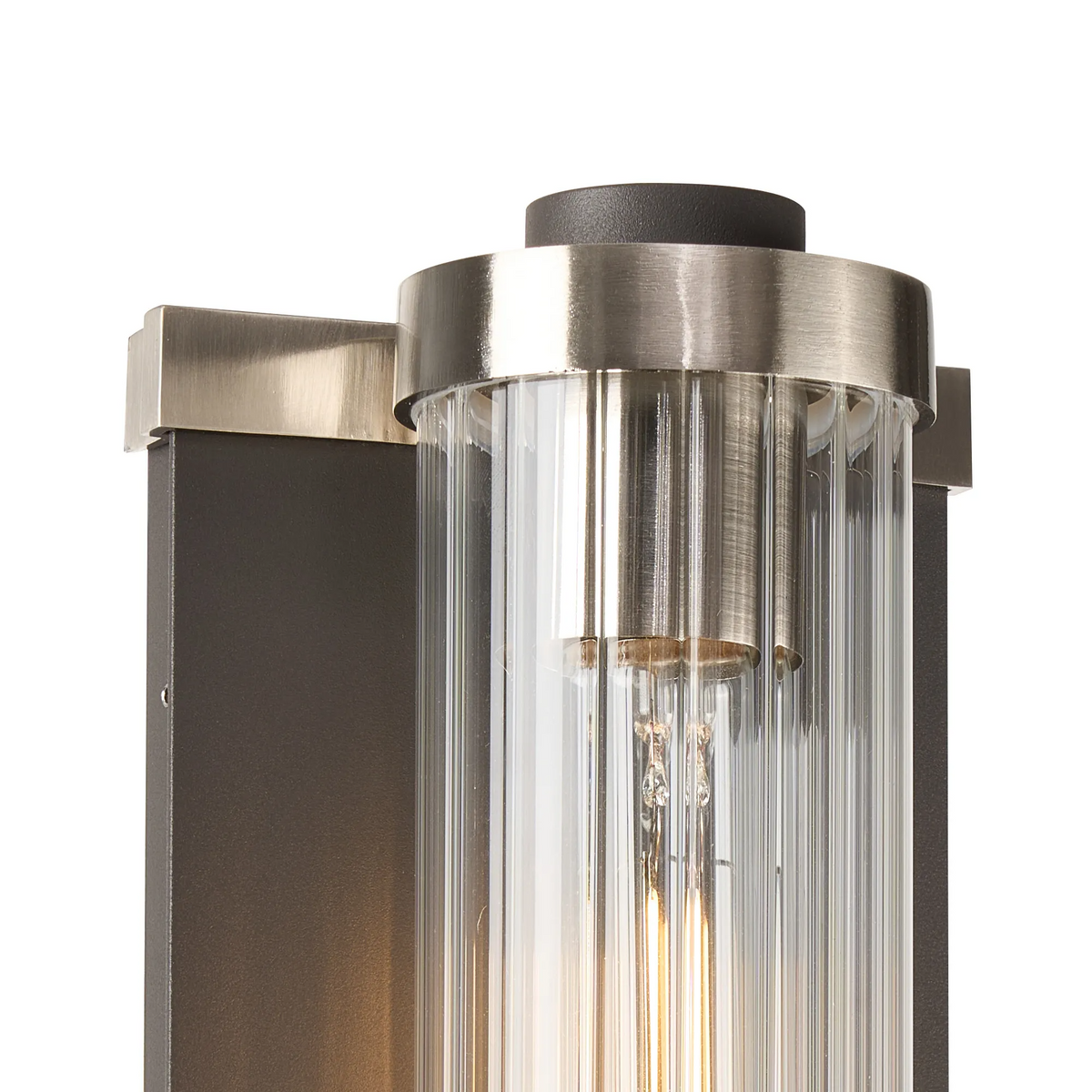 Close up of the top of a vertical wall sconce with a dark bronze backplate and brushed nickel accents