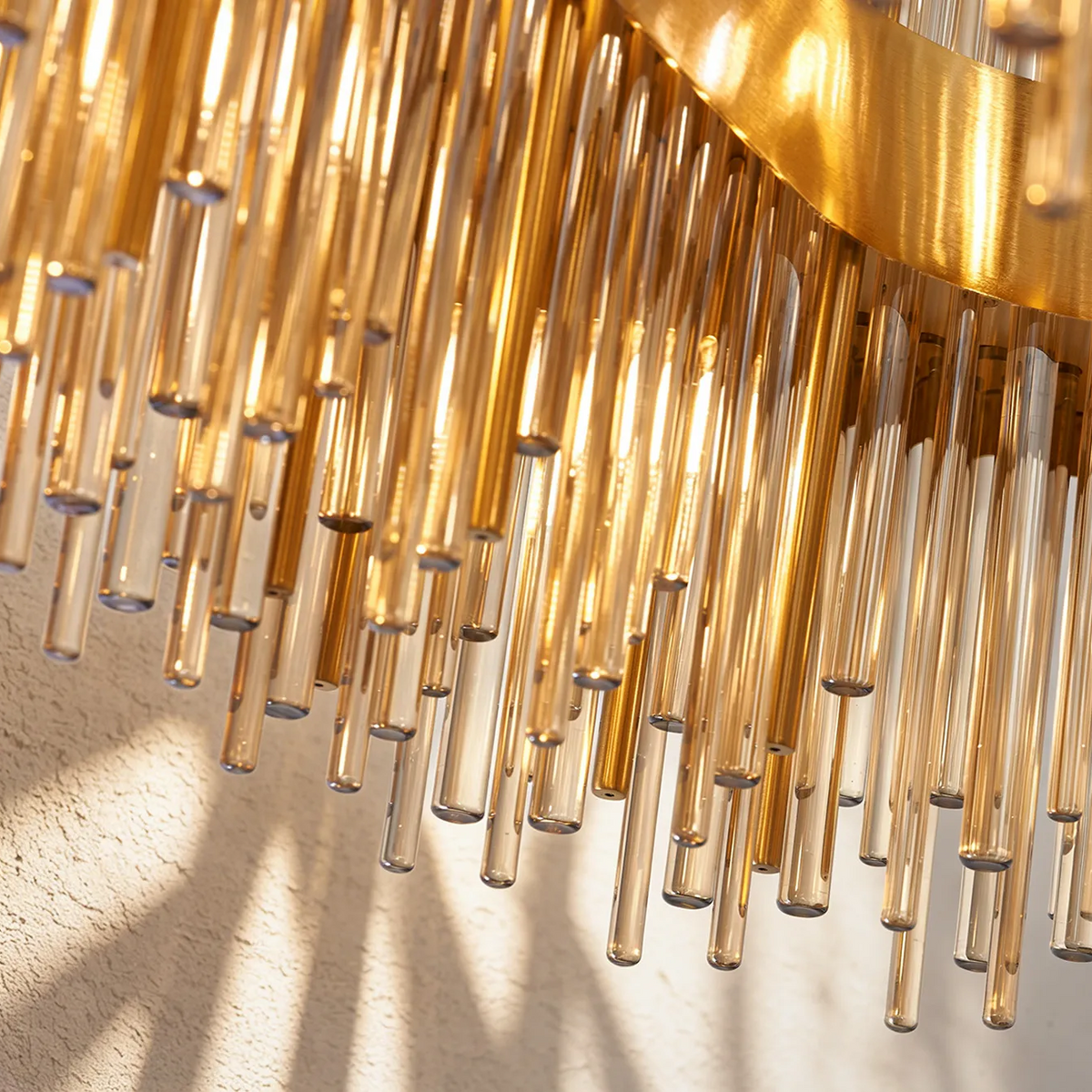 Close up of a gold chandelier with many glass rods hanging down