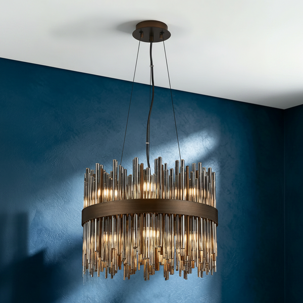 Bronze chandelier with clear glass rods hanging from a white ceiling against a blue wall