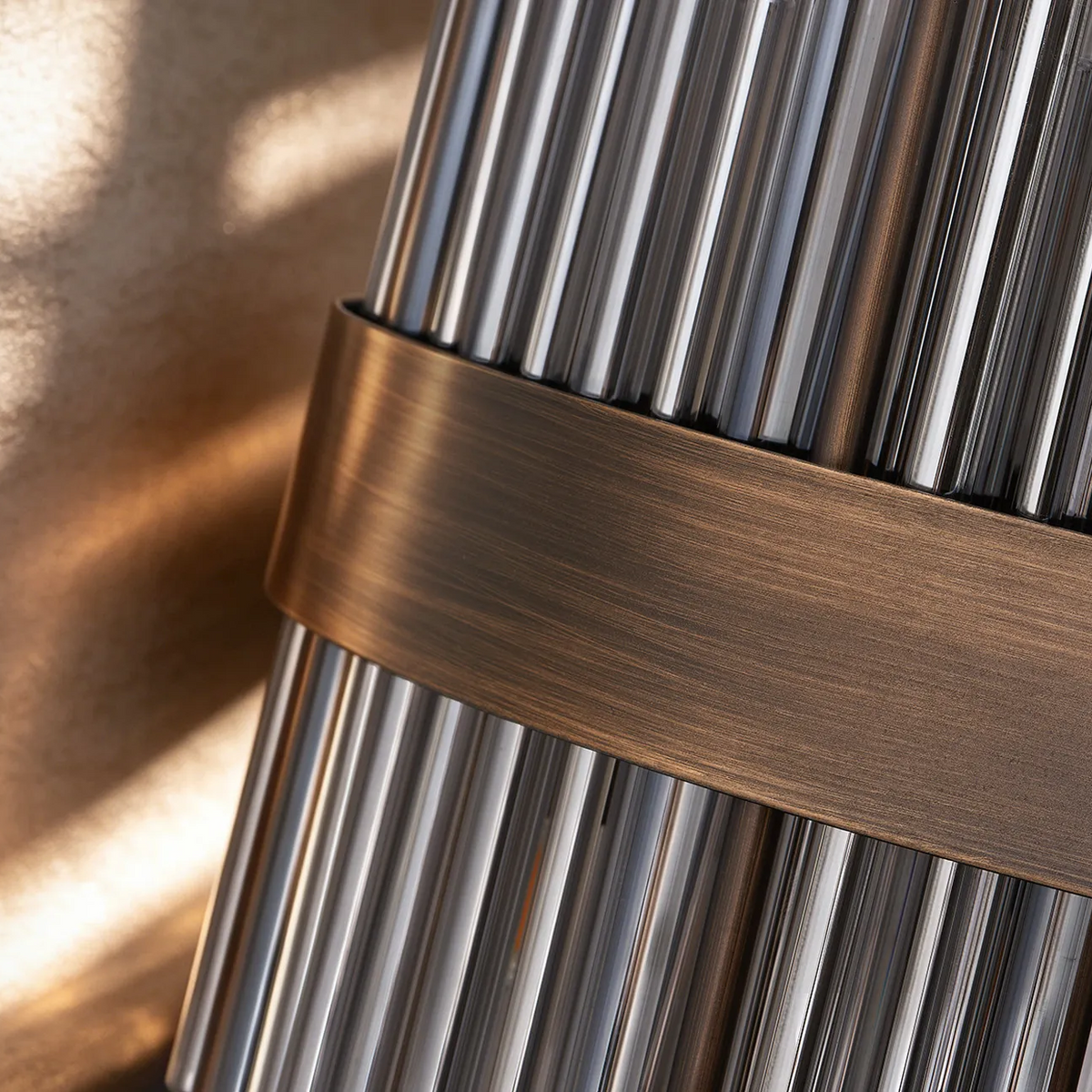 Close up of a lamp with a bronze band around glass rods