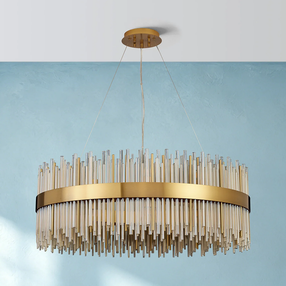 Round chandelier with a gold frame and clear glass rods hanging at varying lengths