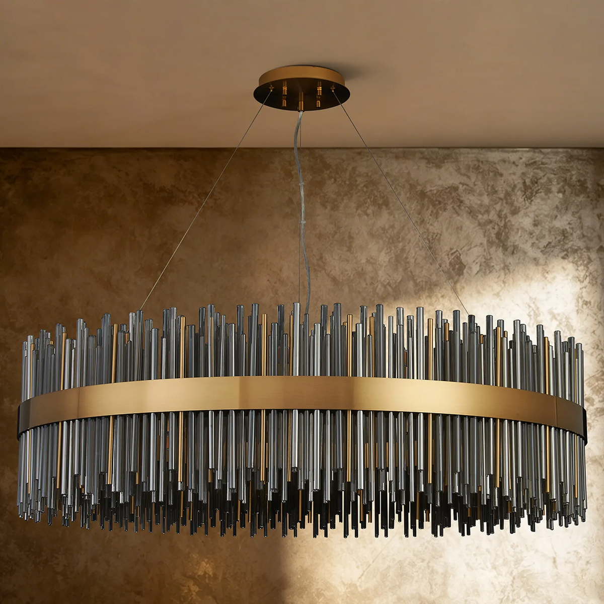 Oval chandelier with a gold band and clear and gold glass rods