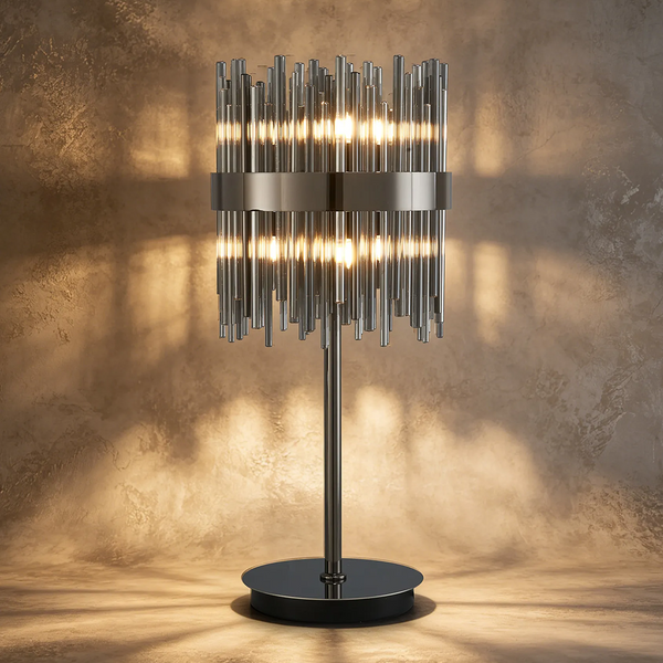 Table lamp with a cylindrical shade made of vertical metal rods, glowing from within, on a dark base