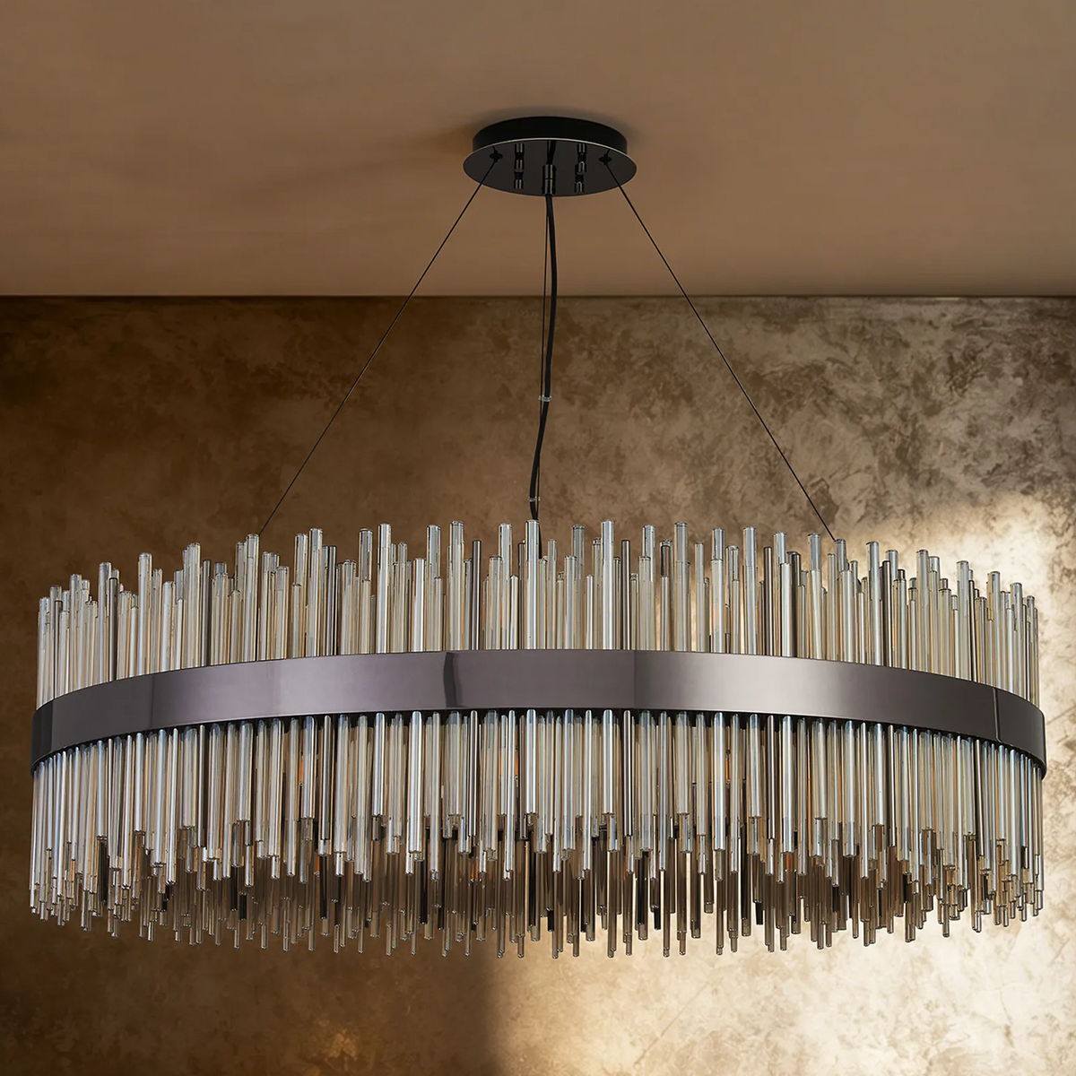 Oval chandelier with a dark metal frame and clear glass rods hanging at varying lengths
