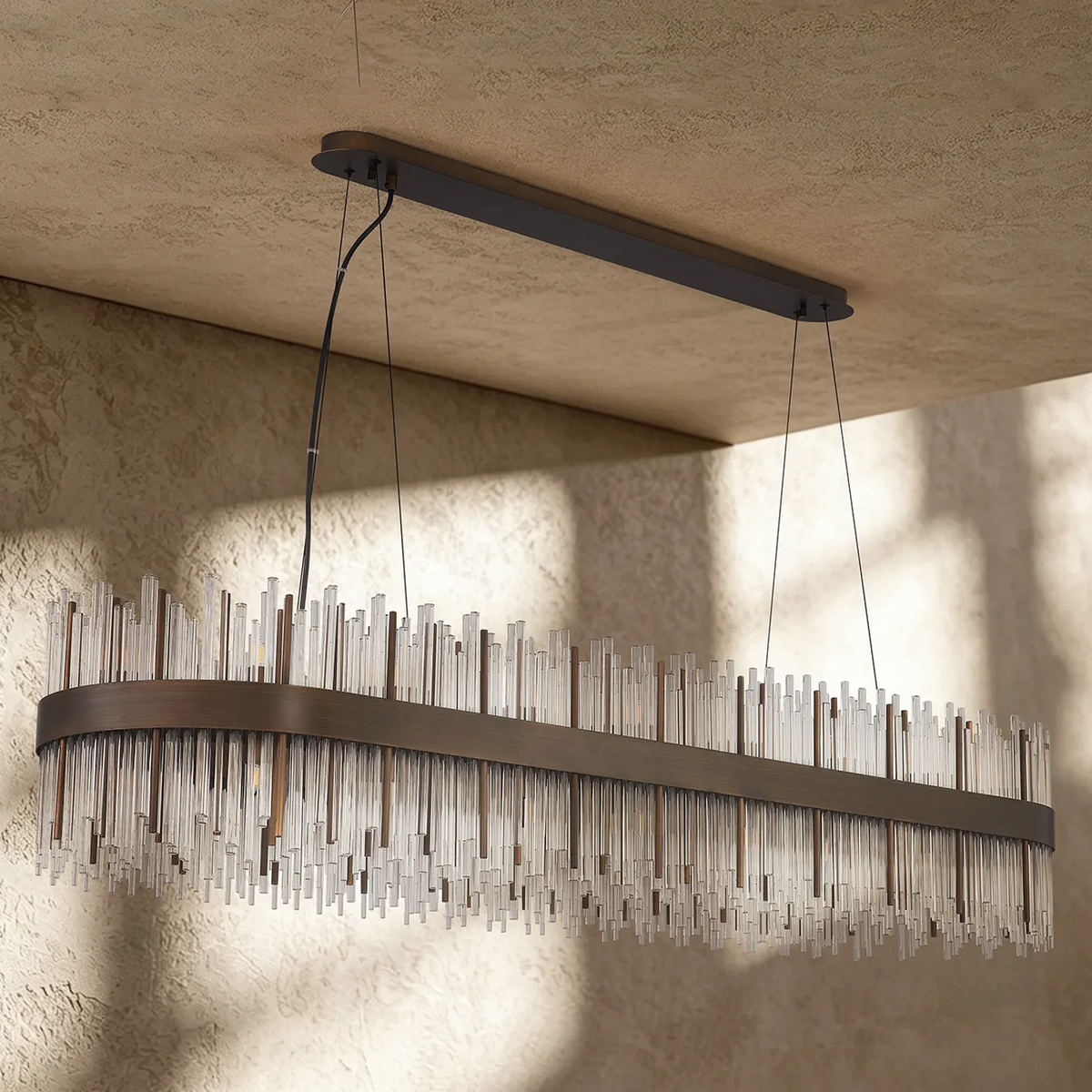 Rectangular chandelier with bronze frame and clear glass rods hanging from a textured ceiling
