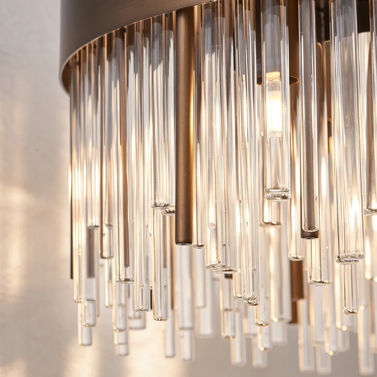 Close up of a modern chandelier with clear glass rods and bronze accents