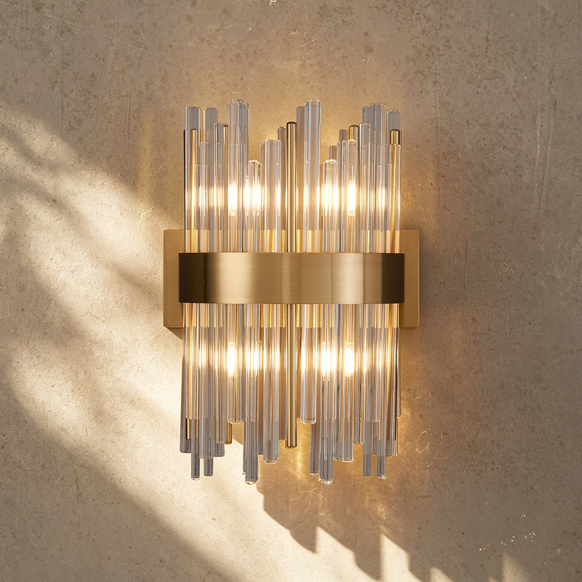 Rectangular wall sconce with vertical clear glass rods and a horizontal brass band
