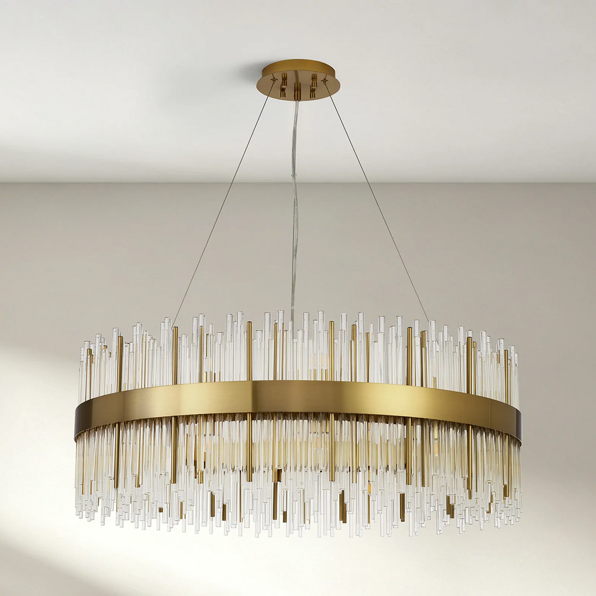 Round brass chandelier with clear glass rods hanging at varying lengths