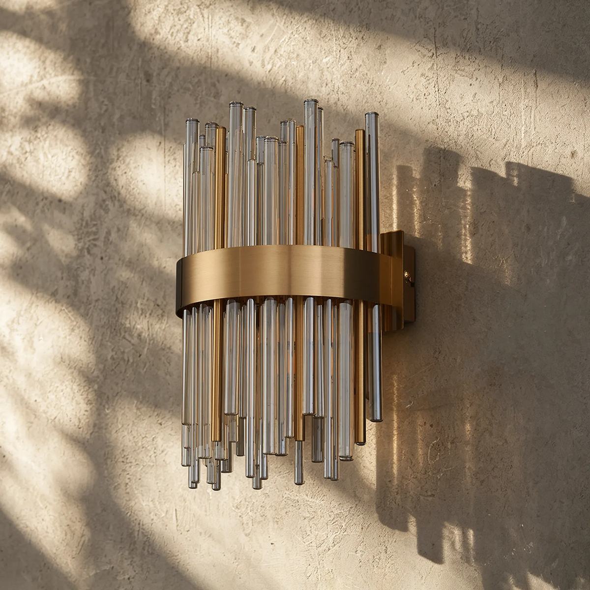 Wall sconce with vertical glass rods and a horizontal brass band