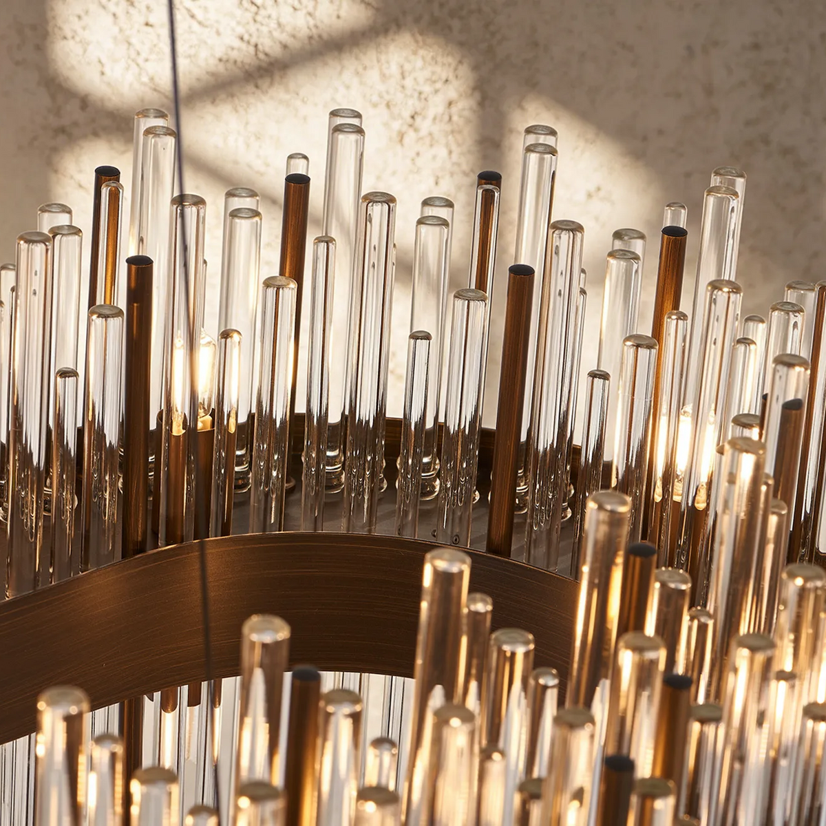 Close-up of a chandelier with clear and bronze glass rods, some illuminated from within