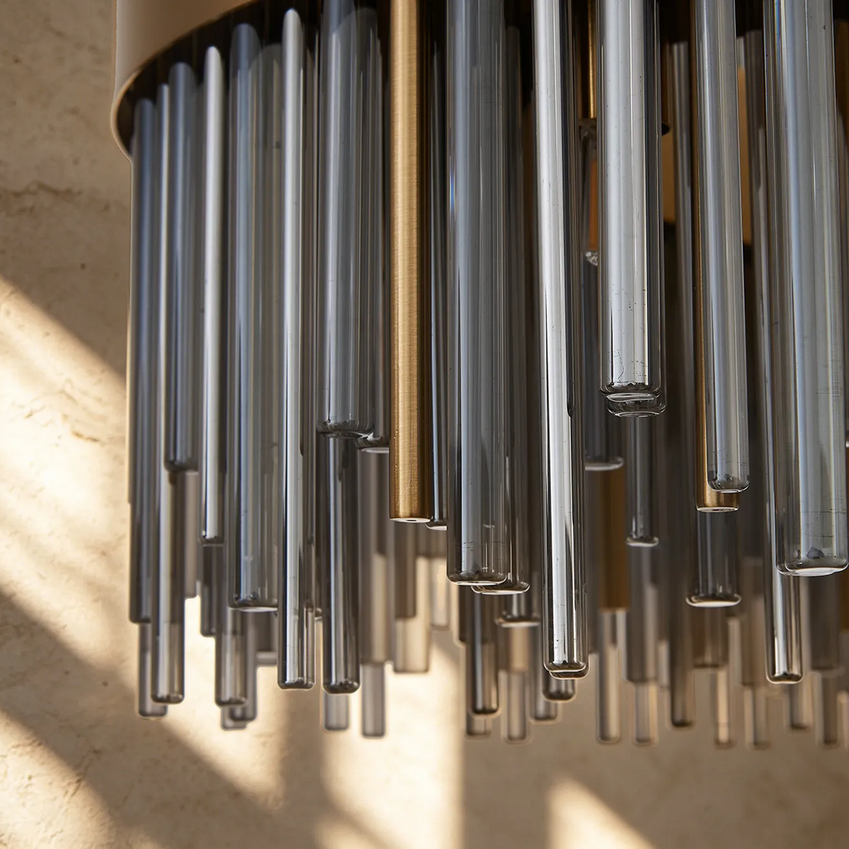 Close up of a chandelier with clear and gold glass rods hanging down