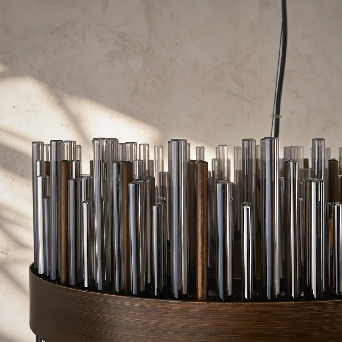 Close-up of a chandelier with clear and bronze glass rods in a circular bronze base