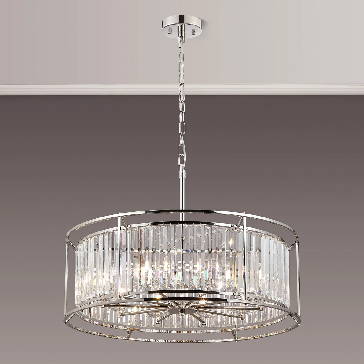 Round crystal chandelier with chrome frame and chain hanging from a ceiling