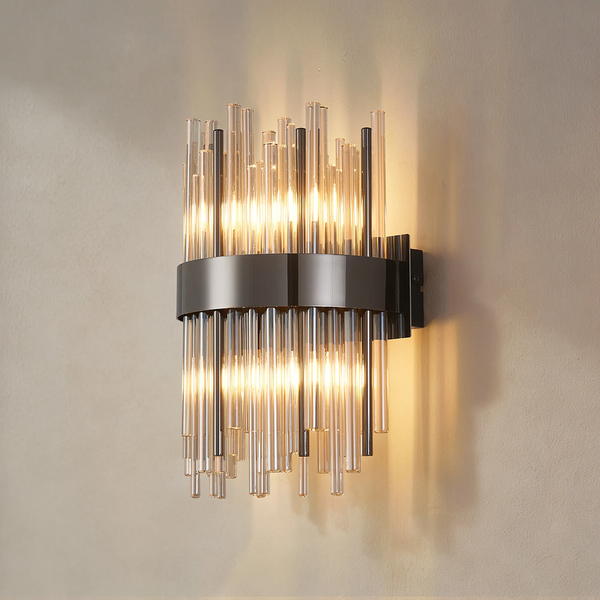 Modern wall sconce with clear and dark glass rods, illuminated from within, mounted on a light-colored wall