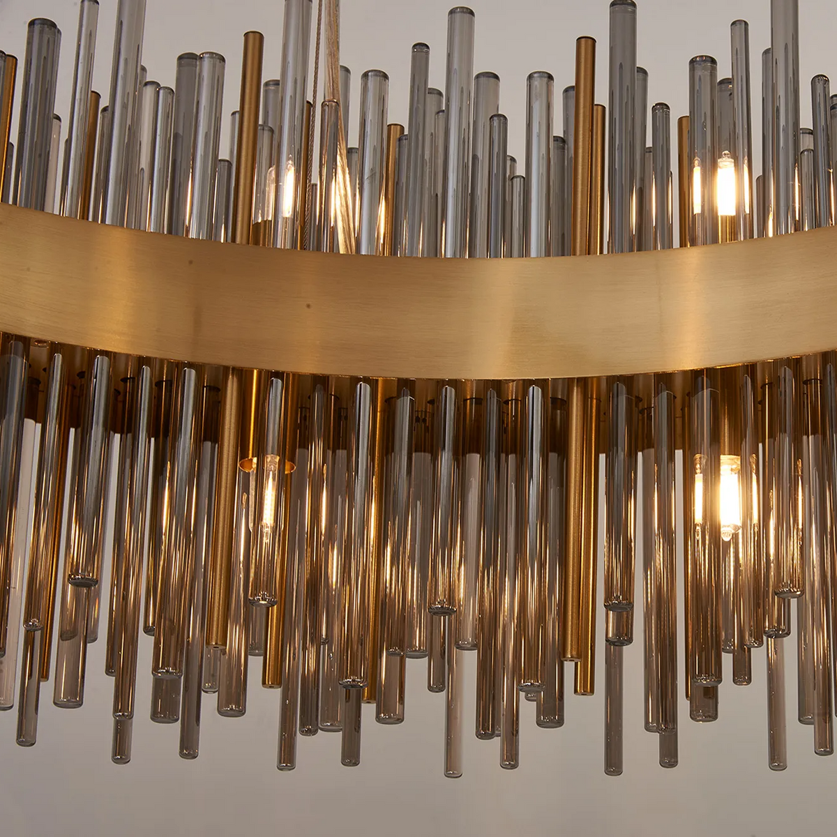 Close up of a chandelier with a gold band and clear and amber glass rods