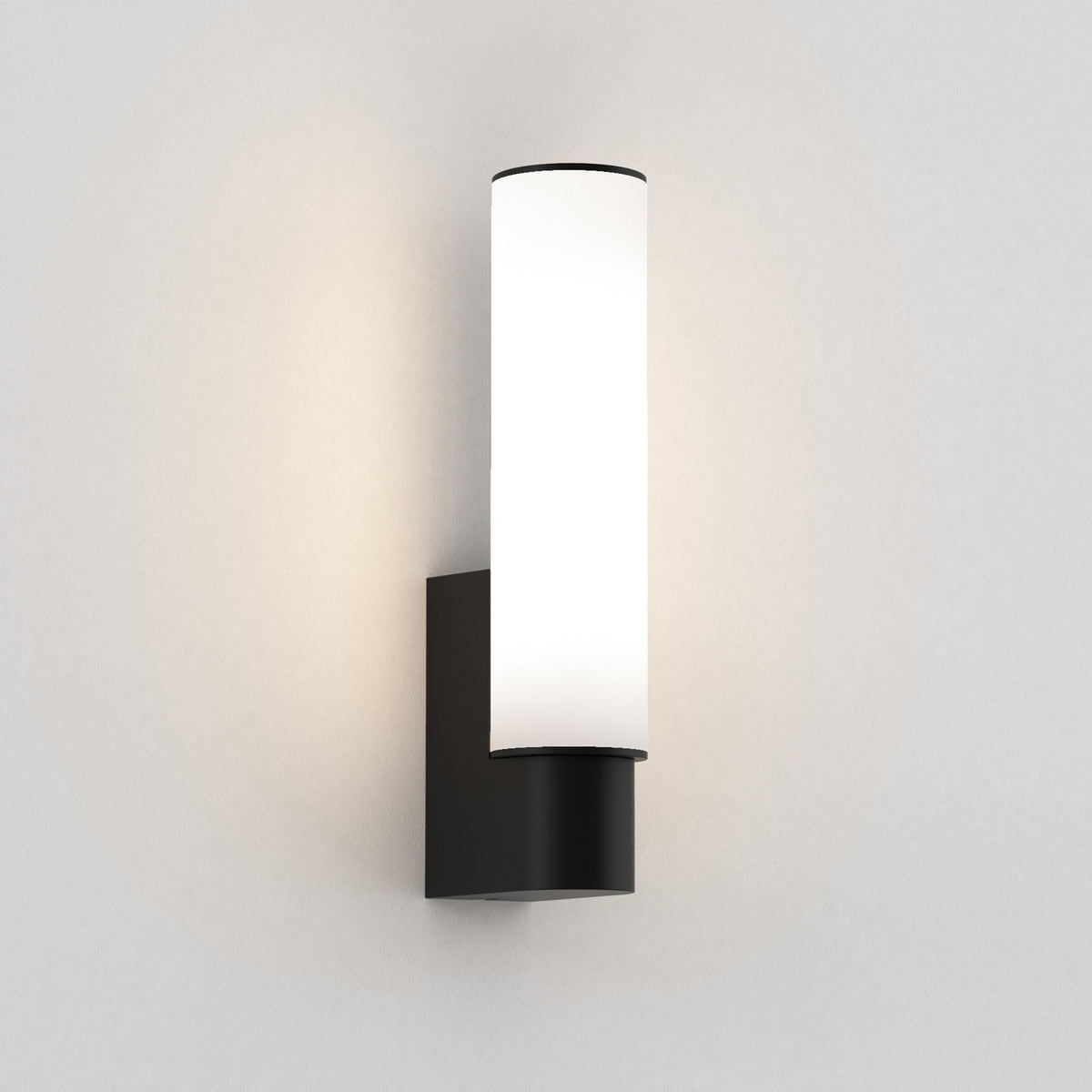 Black wall sconce with a cylindrical white diffuser
