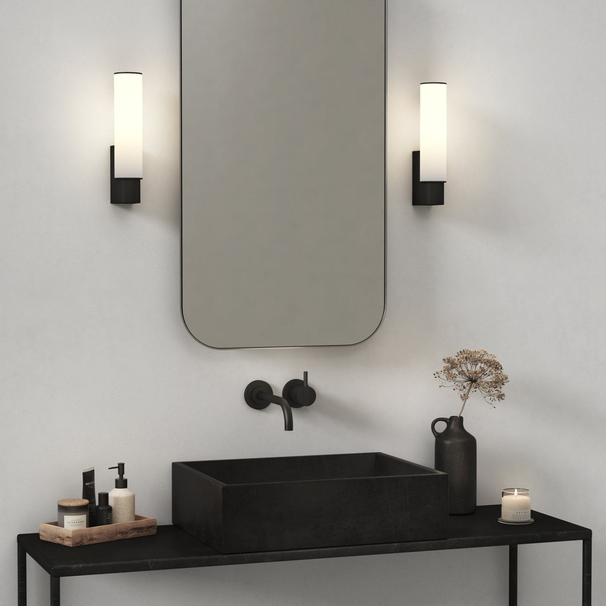 Modern bathroom with a black rectangular sink, black wall-mounted faucet, and a large mirror with two vertical lights