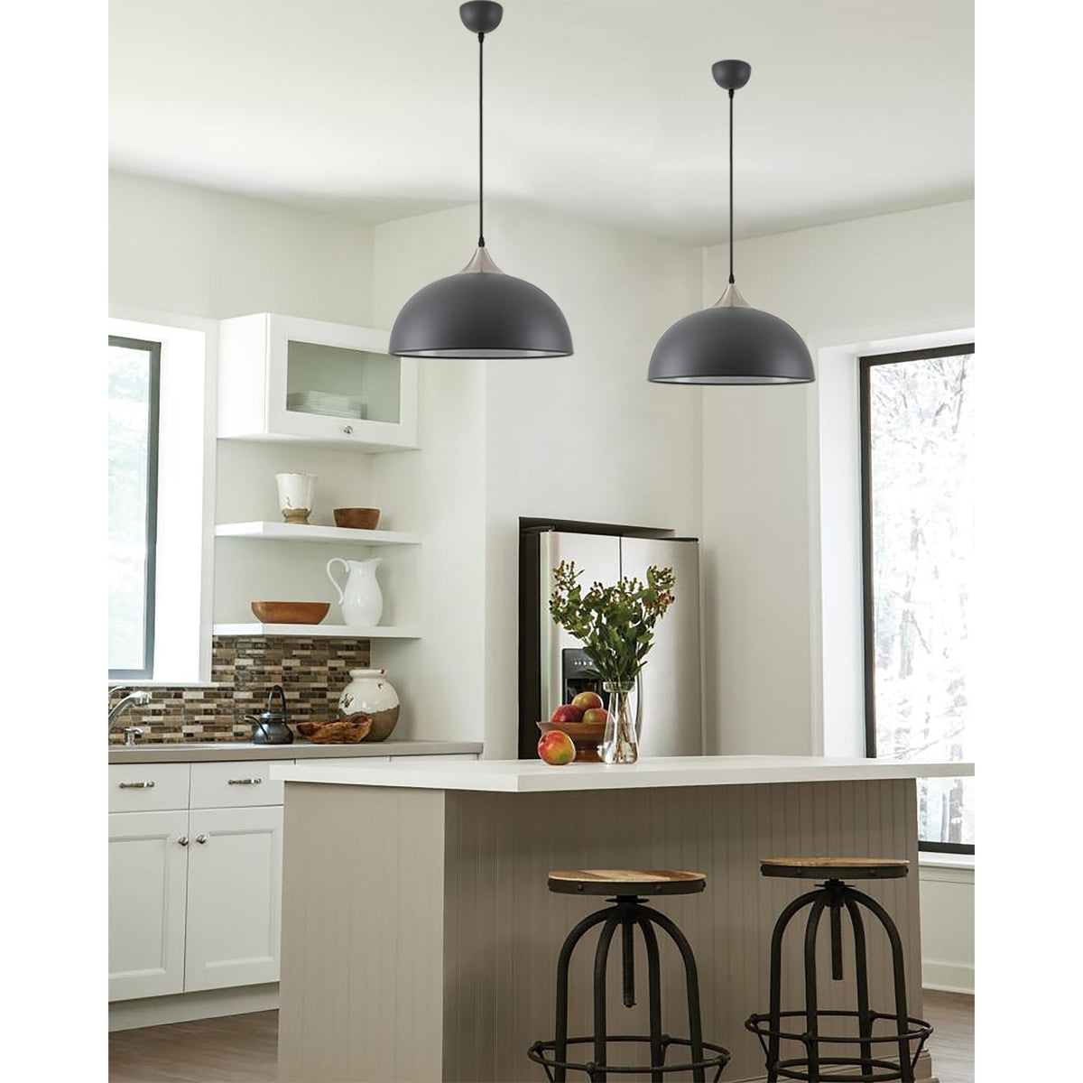 Two black pendant lights illuminate a kitchen island with stools.