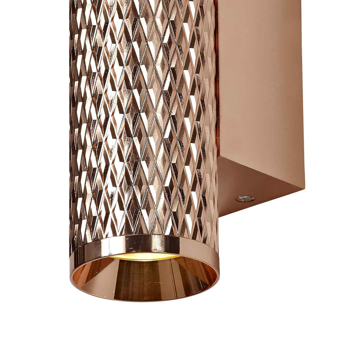 A close-up of the bottom of a rose gold textured wall light.