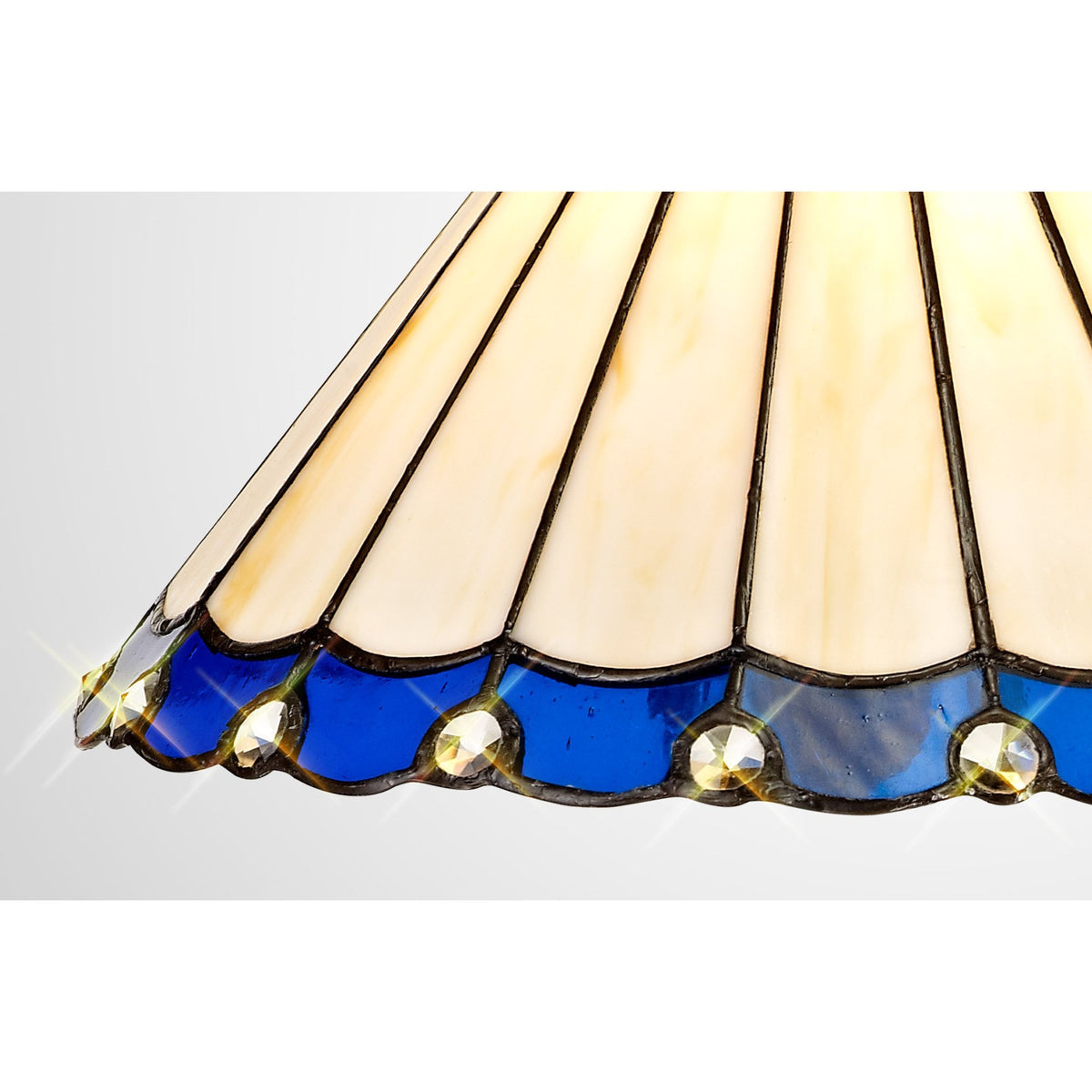 A close up of the jewelled scalloped edge of the Tiffany style lampshade, at an angle.