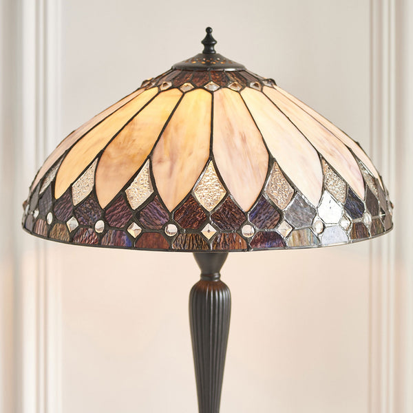 Close-up of the ornate glass shade of a table lamp with varied patterns.