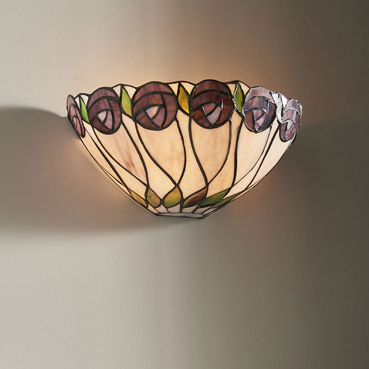 A Tiffany wall light with purple stained glass flowers mounted on a wall.