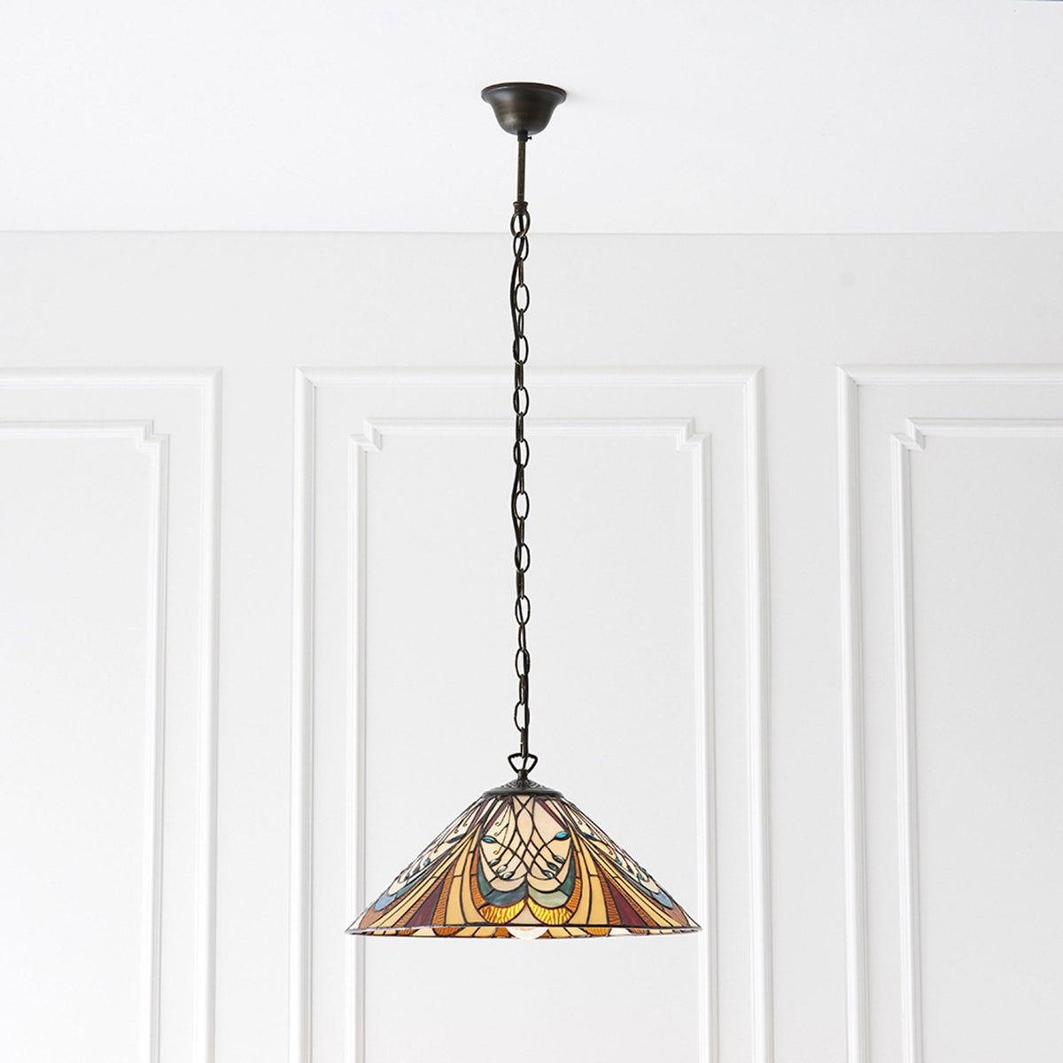 A Tiffany-style pendant light with a multicoloured glass shade hanging against a white paneled wall.