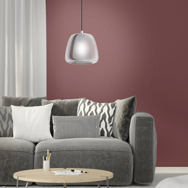 A modern chrome pendant light illuminates a cosy living room with a grey sofa and pink wall.