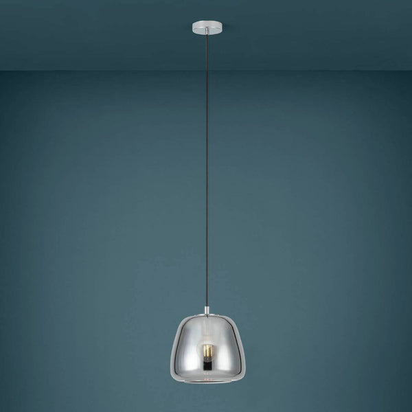 A sleek chrome pendant light hangs against a teal wall, showcasing its reflective finish.