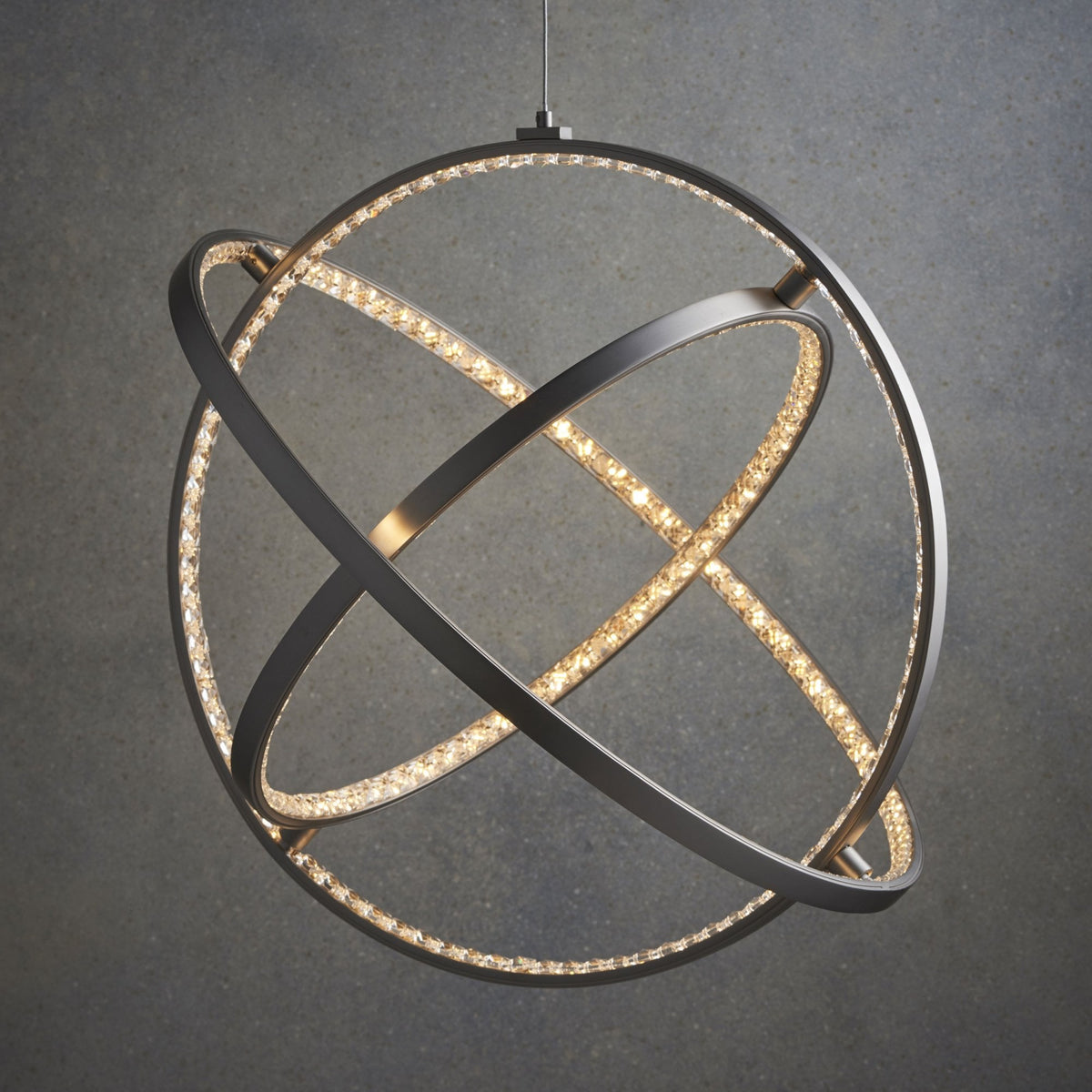 An illuminated pendant light with multiple intersecting rings, against a dark background.