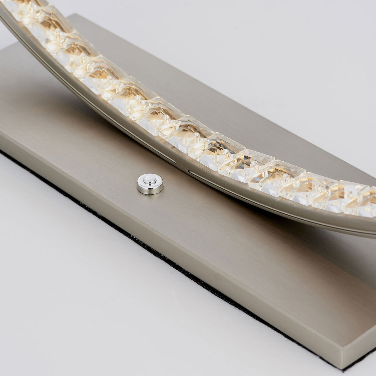 Close-up of the lamp's base and lower illuminated ring, showing crystal details and power button.