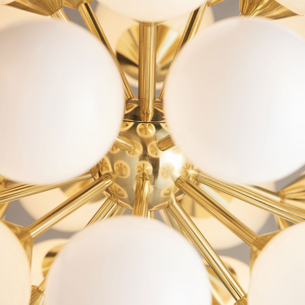 Close-up of the gold frame and white spherical lights of a modern chandelier.