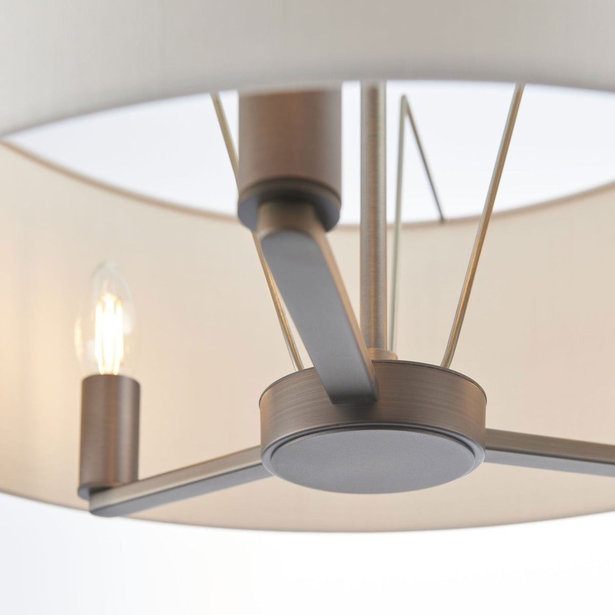 Close-up of the drum pendant light showing the dark bronze frame and a single exposed bulb.