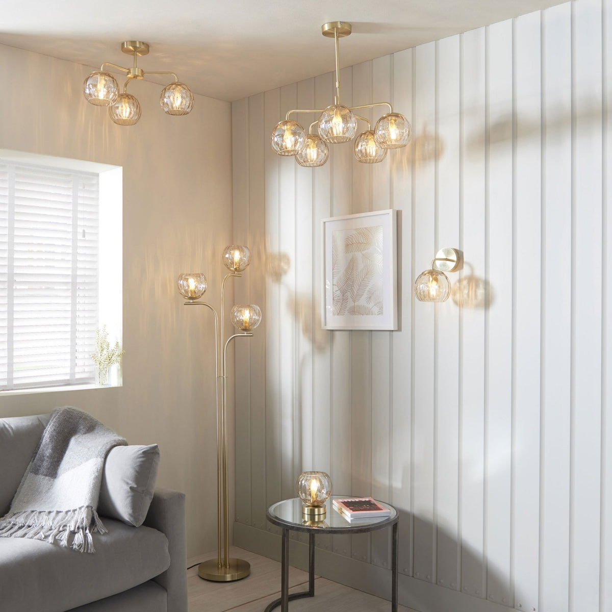Living room with a matching collection of brass and glass light fixtures, including a ceiling light, floor lamp, and wall light.
