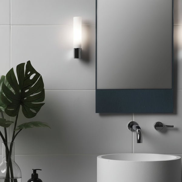 Bathroom with white tiles, a mirror, a plant, a sink, and a wall-mounted light