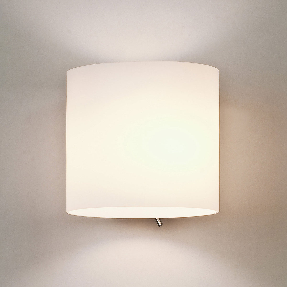 White cylindrical wall sconce with a light shining from the top and bottom
