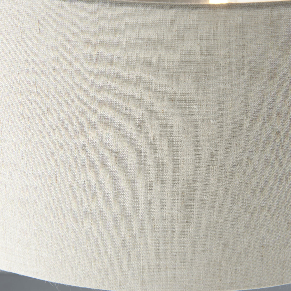 Close-up of the textured light fabric shade of a floor lamp.