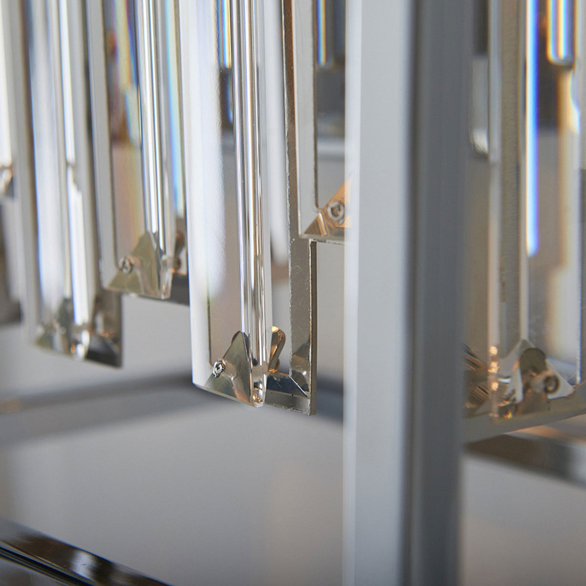 Close-up of the bottom of clear crystal rods within a chrome light fixture.