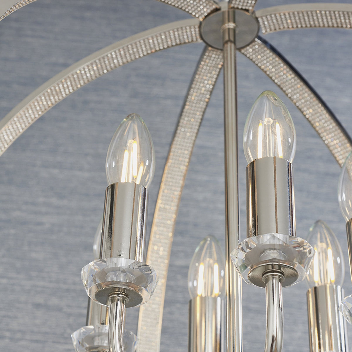 Close-up of the chandelier showing the top of the spherical frame adorned with crystals.