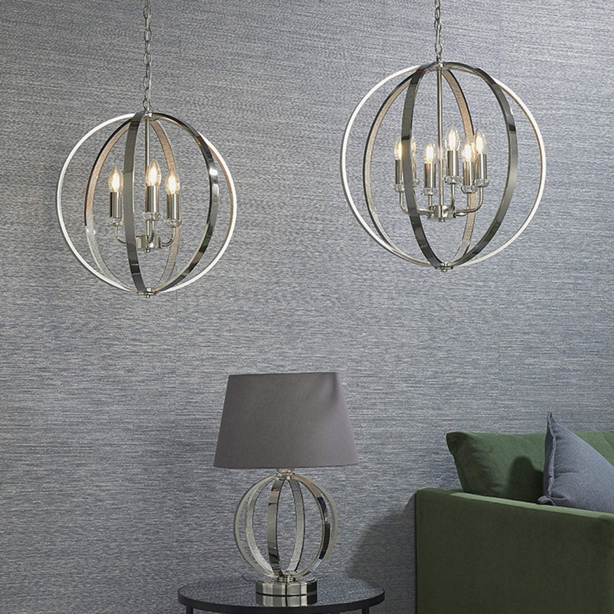 Two polished nickel chandeliers and a matching table lamp in a living room setting.