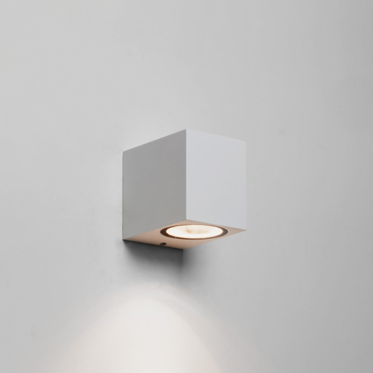 White cube-shaped wall light with a circular downward-facing bulb