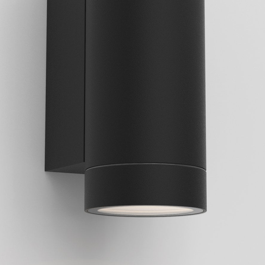 Black cylindrical outdoor wall light with light shining downwards