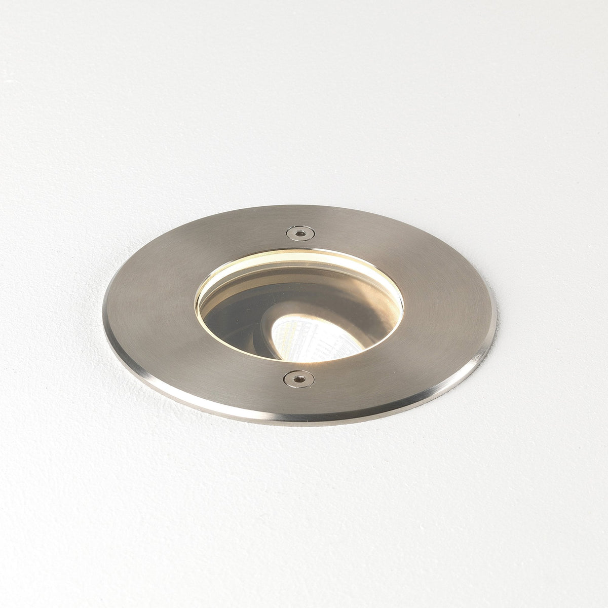 Round brushed metal recessed light fixture with a warm glow