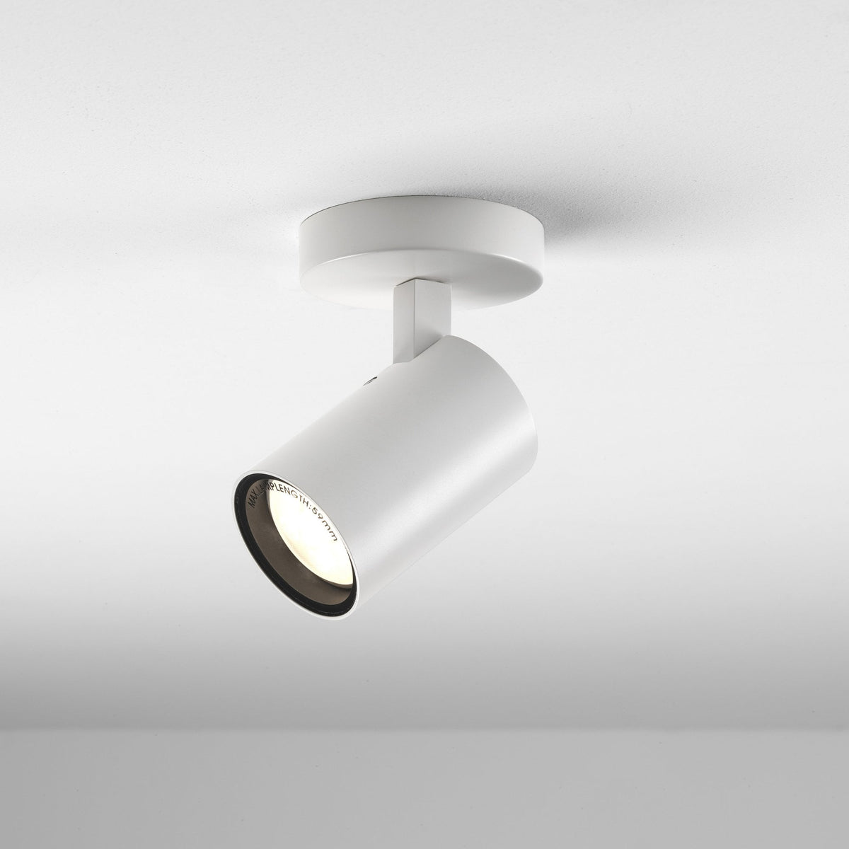 White ceiling mounted spotlight with a cylindrical head and a warm light