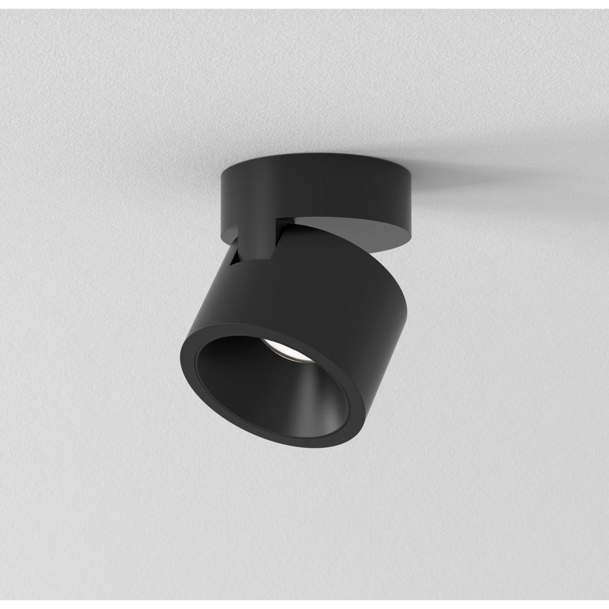Black ceiling spotlight with a cylindrical head and a round base