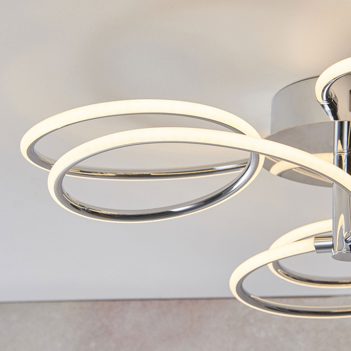 Detail of the illuminated rings on a modern chrome ceiling light.